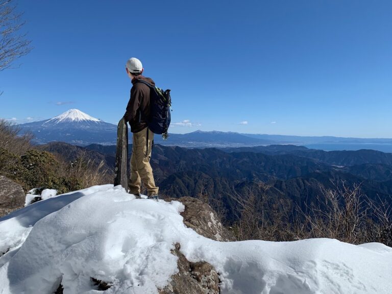 雪の残る山頂に立つヤマイズ